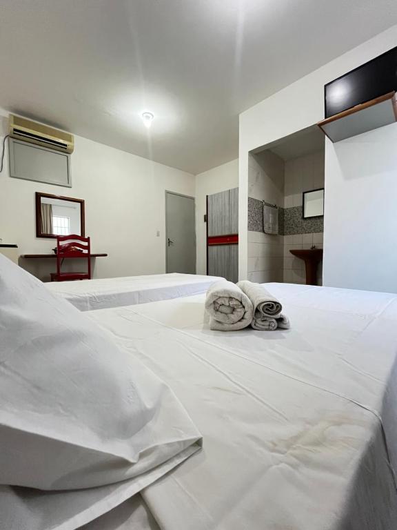累西腓Malakoff Residence的一张白色的大床,带两条毛巾