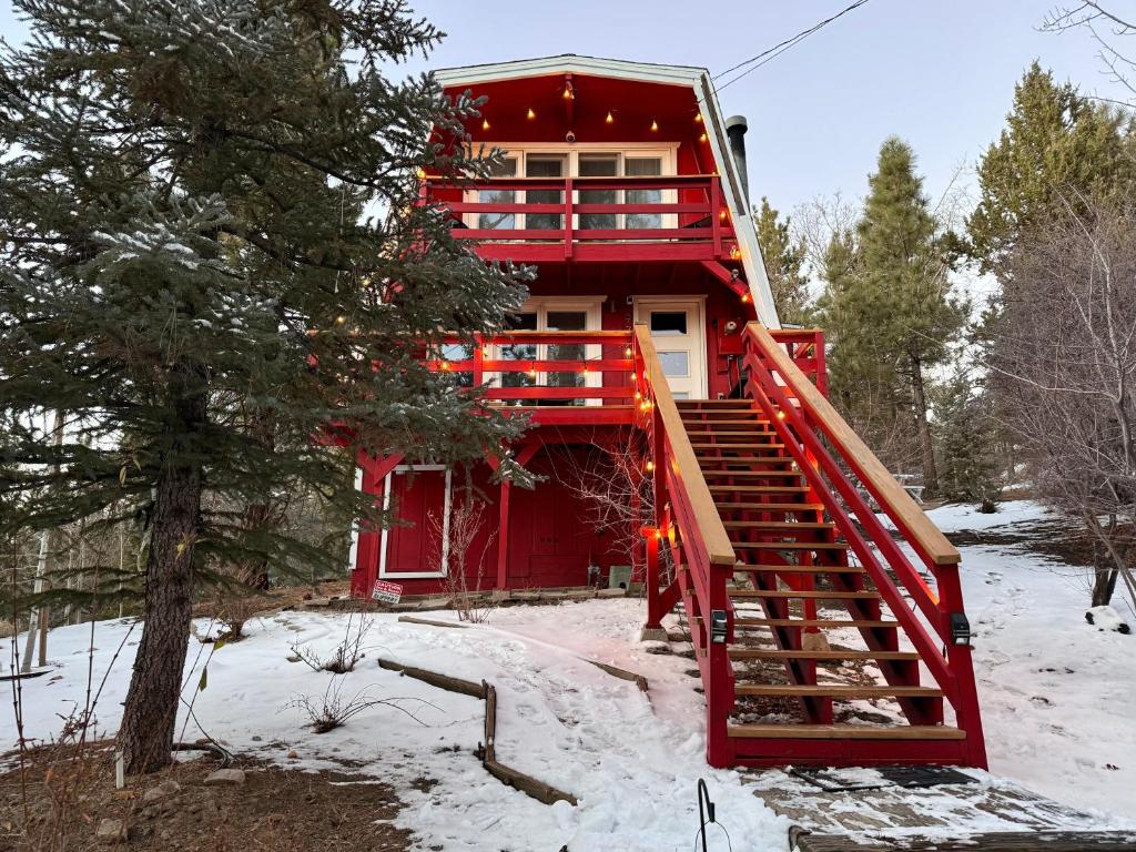 大熊湖Maison Solange-Red Barn Farmhouse Style- Moonridge的雪中红色的房屋,有红色的楼梯