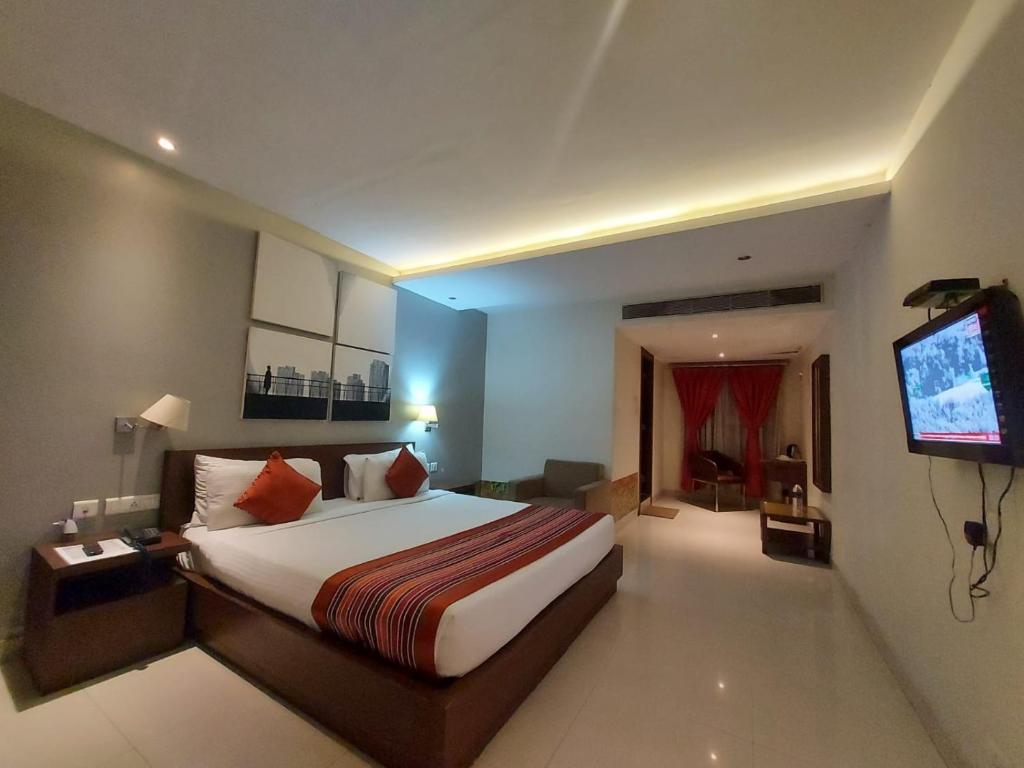 BāghdograOrbit Hotel的酒店客房,配有床和电视