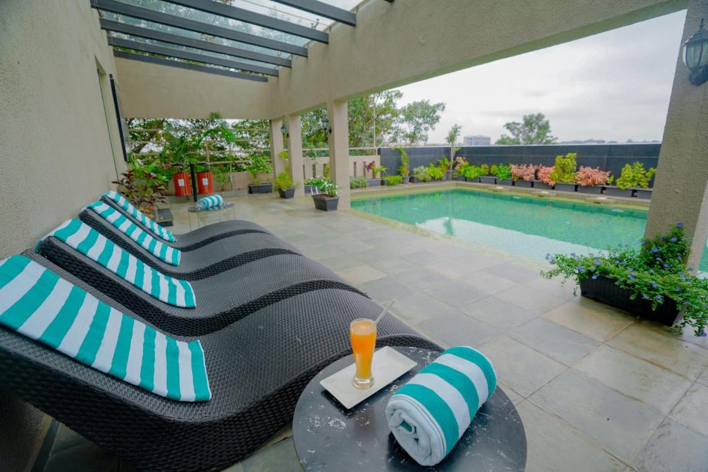 班加罗尔Lazdana Hotel Bangalore的带沙发和游泳池的天井