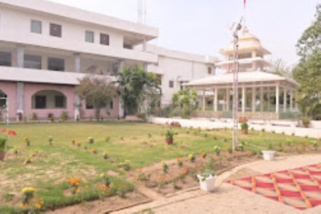 瓦拉纳西Vedic Villa,Varanasi的建筑前带花园的建筑