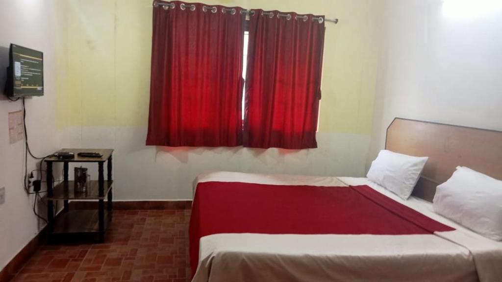 科代卡纳尔FLGHR Green Residency的一间卧室配有一张红色窗户的床
