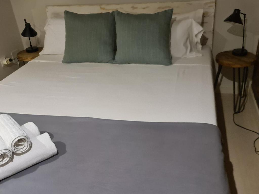巴达洛纳Bda plaja的一张带两个枕头和毛巾的大型白色床