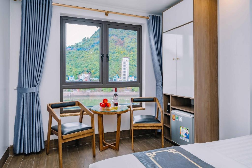 吉婆岛Bao Phuc Hotel的客房设有桌子、两把椅子和窗户。