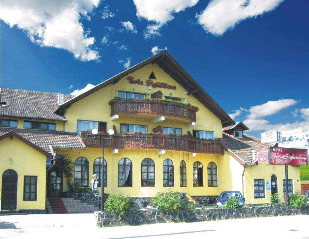 锡盖图马尔马切伊佩拉赛贺提娜汽车旅馆的黄色的建筑,上面设有阳台