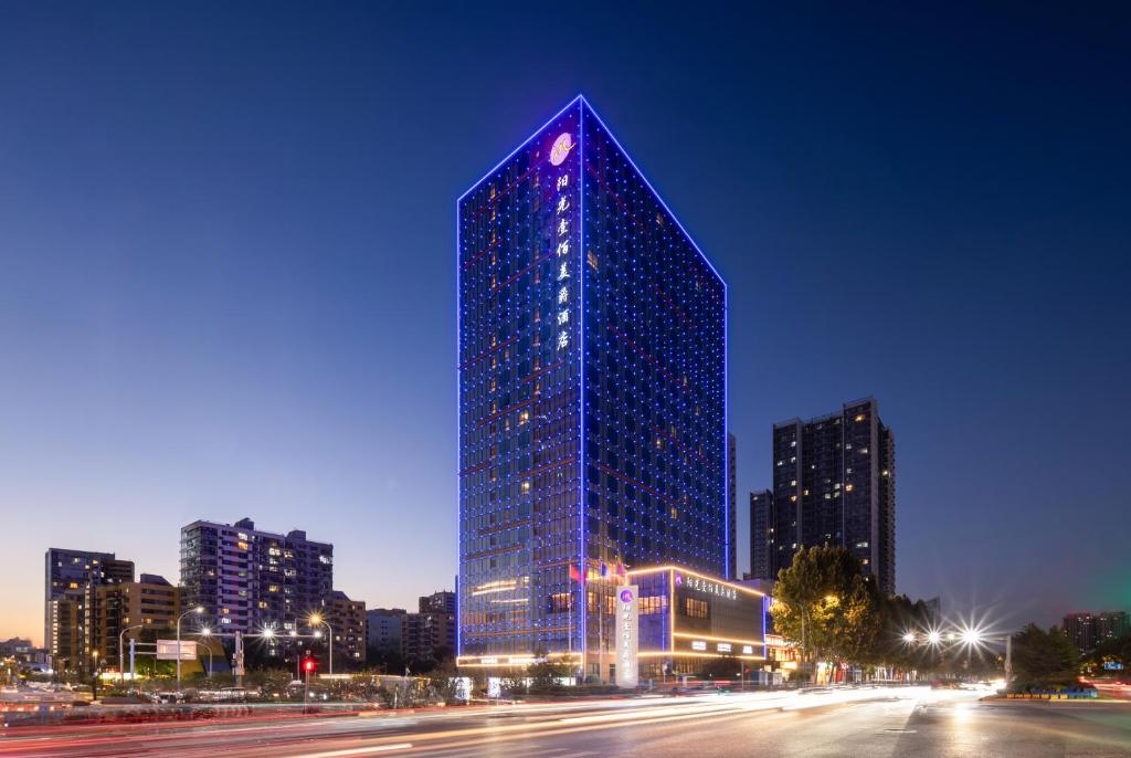 济南济南阳光壹佰雅高美爵酒店的夜晚在城市里高大的蓝色建筑