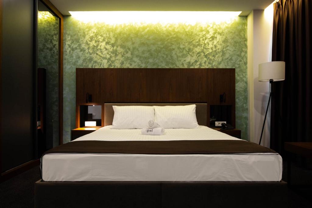 斯特鲁加Hotel Bograd - Apartments & Lounge Station的一间卧室配有一张大床和大床头板
