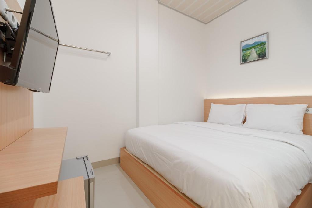 日惹Urbanview keTemon Hotel & Resto YIA by RedDoorz的一间卧室配有一张床和一台平面电视
