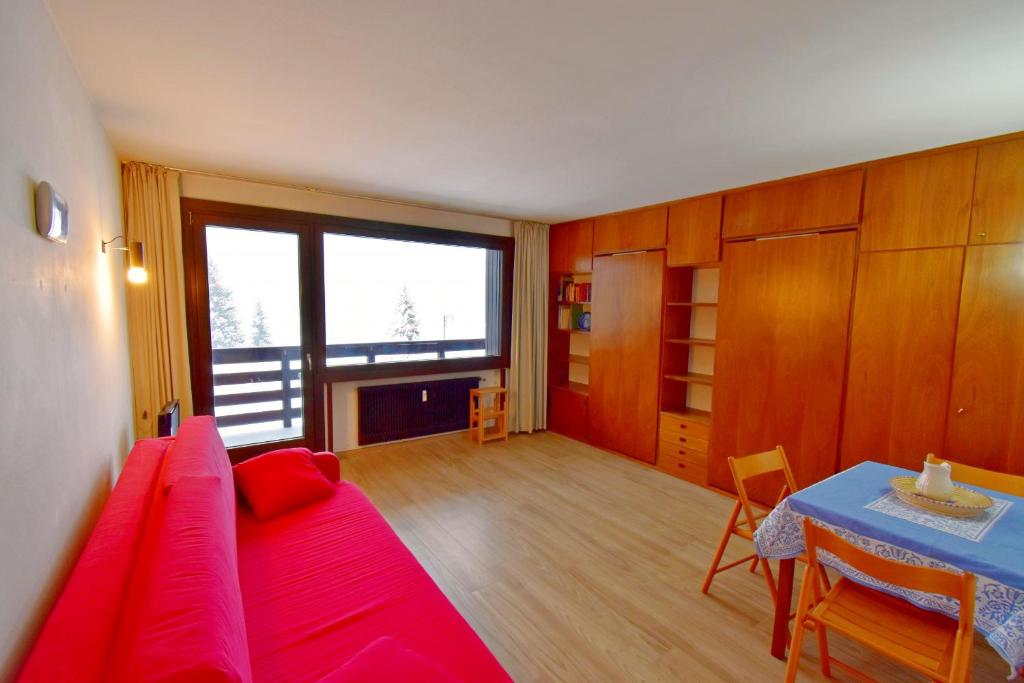 摩德纳迪-坎皮格里奥Carlo Magno Studio apartment的一间卧室配有红色的床和一张桌子