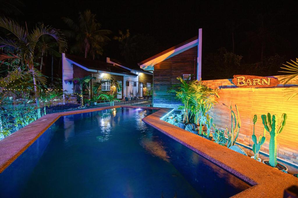 邦劳Barn Hostel的夜间在房子前面的游泳池