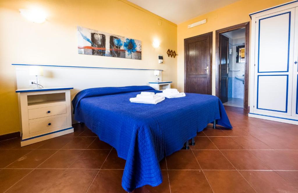 斯廷蒂诺佩罗塞塔公寓式酒店的一间卧室配有蓝色的床和毛巾