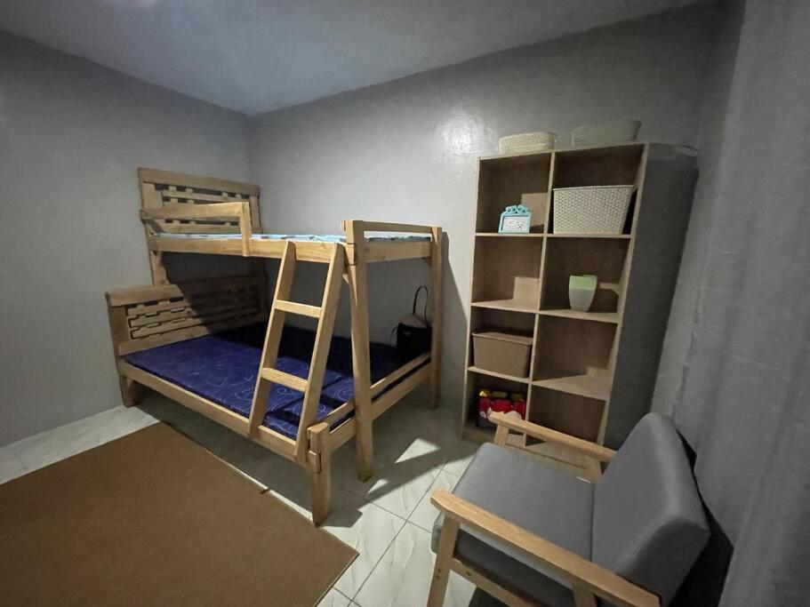 Iba2B Tiny Home in Iba Zambales的带两张双层床和椅子的房间