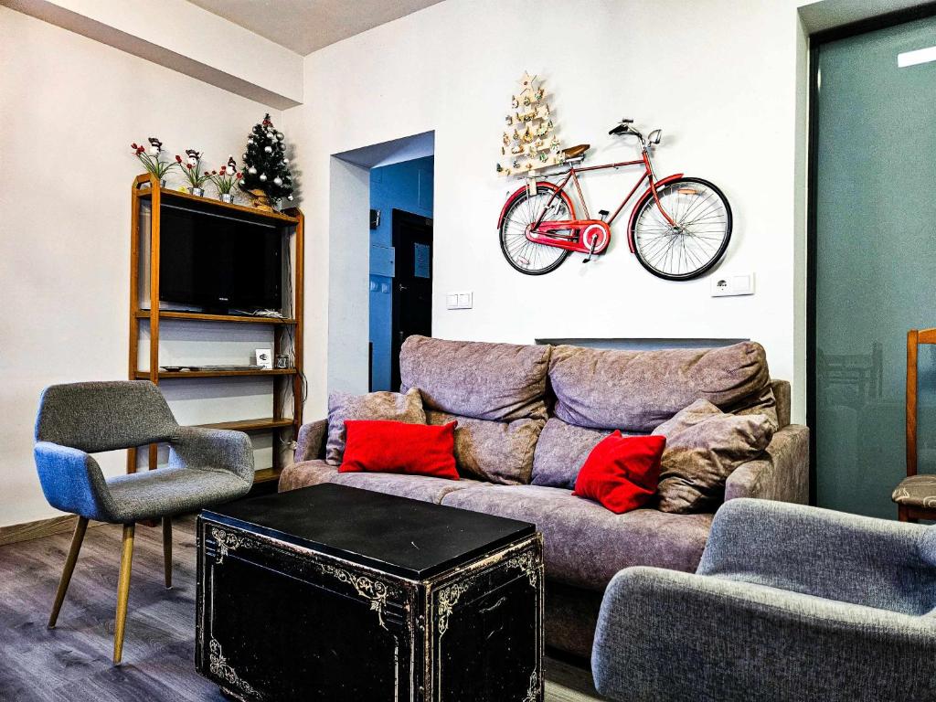 莱昂Oak House Oakplacescom的客厅配有沙发,墙上有自行车