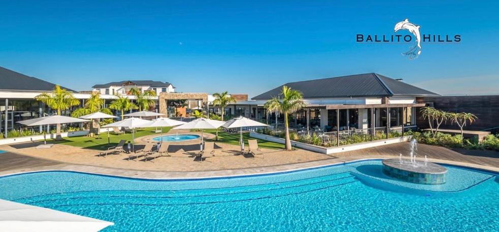 巴利托Ballito Splash的一个带遮阳伞的游泳池和一个度假村