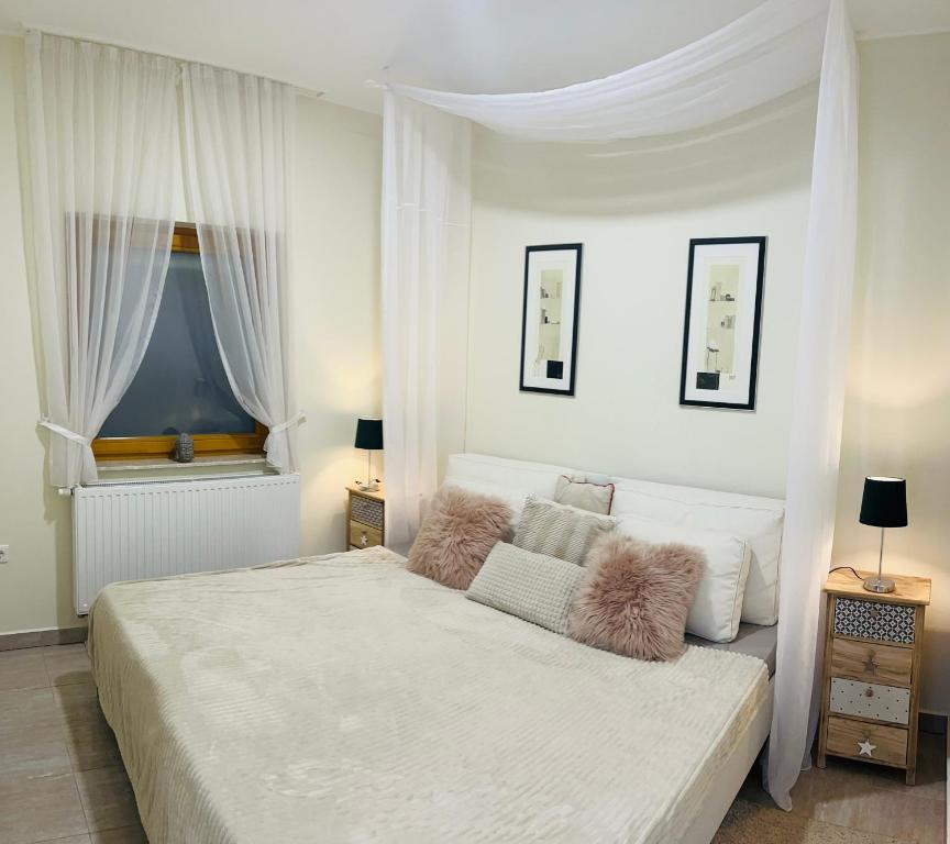 加尔多尼Villa Relax Apartman的卧室配有白色大床和白色窗帘