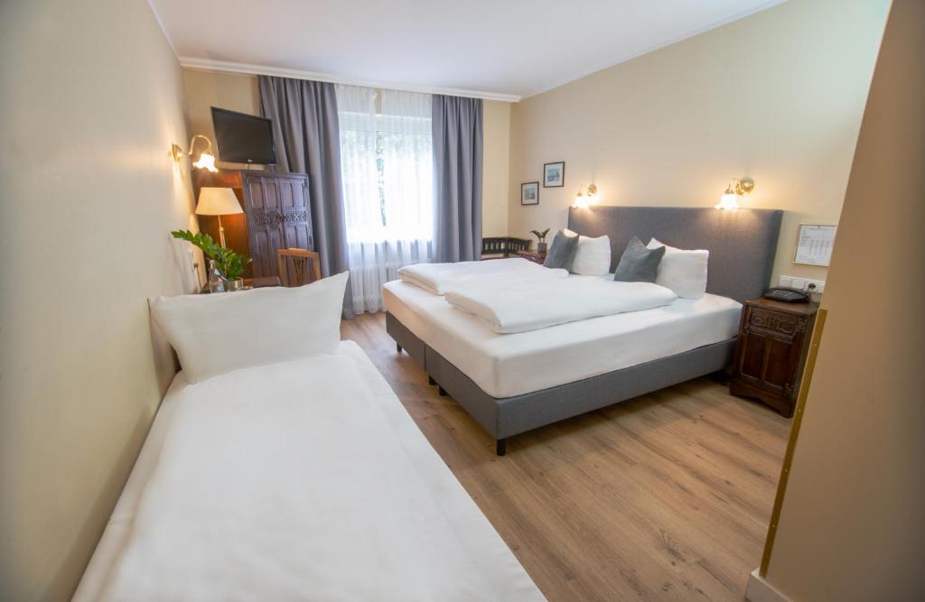 慕尼黑Hotel Altmünchen by Blattl的酒店客房,设有两张床和镜子
