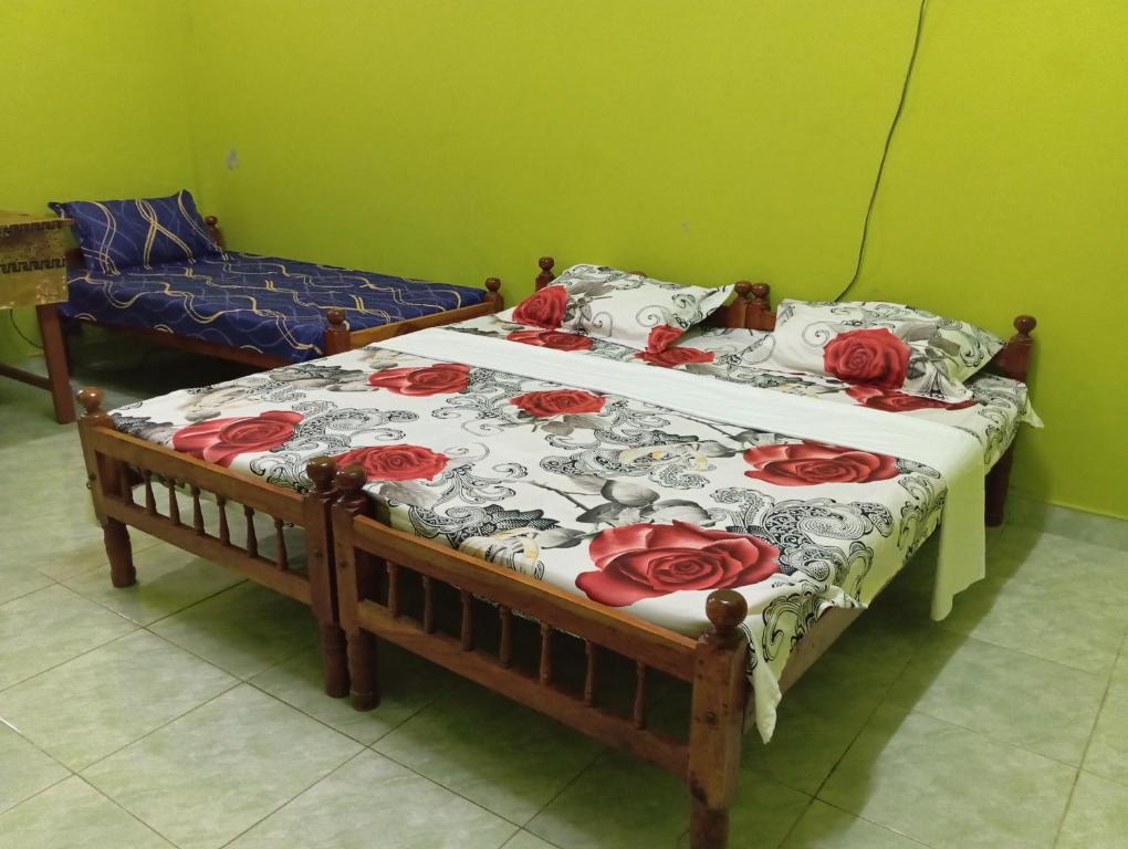 贾夫纳Nallur Mylooran Arangam的一间卧室配有两张红色玫瑰床。
