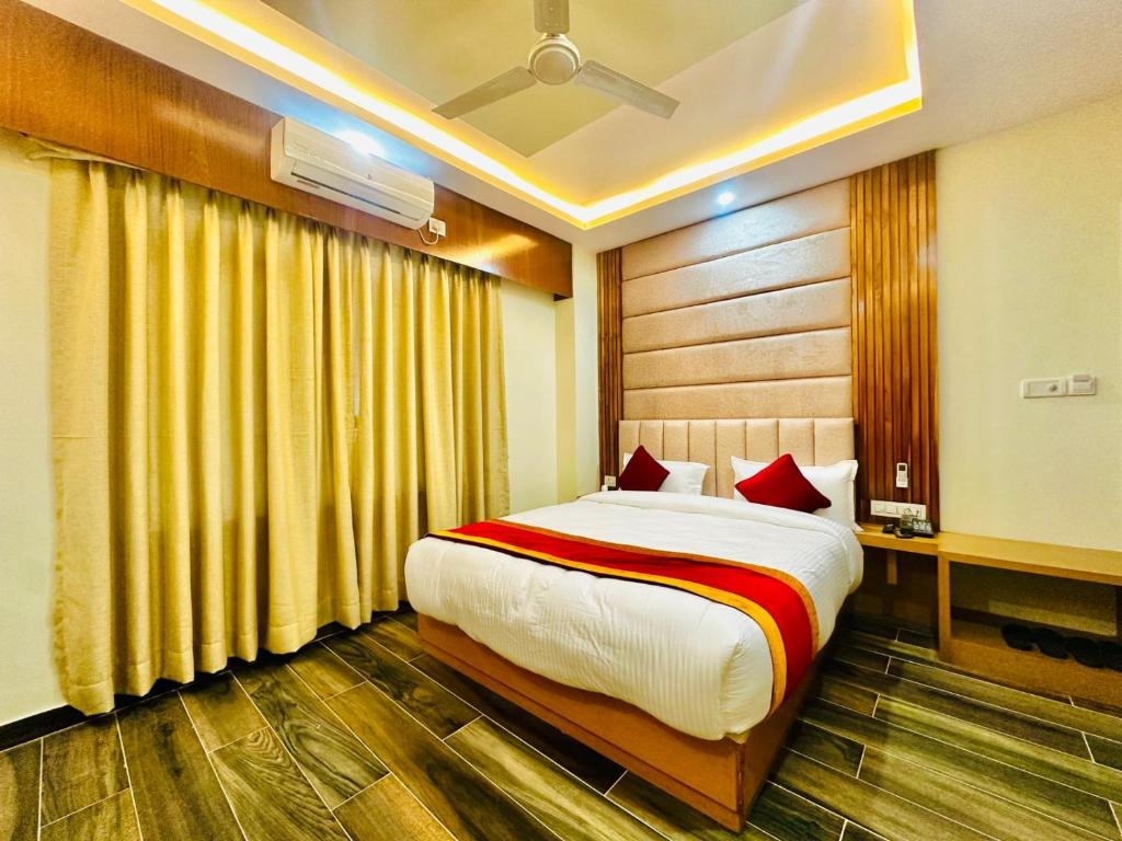 拜拉哈瓦Hotel Ultra International的一间卧室配有一张带红色枕头的大床