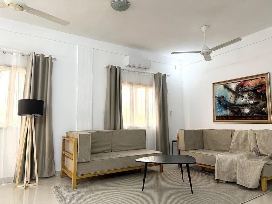瓦加杜古Appartement - Le Grège的客厅配有沙发和桌子