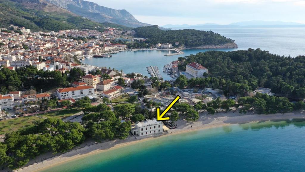 马卡尔斯卡Beach rooms Riviera - Žuta Kuća的有一个黄色箭头指向水中的岛屿