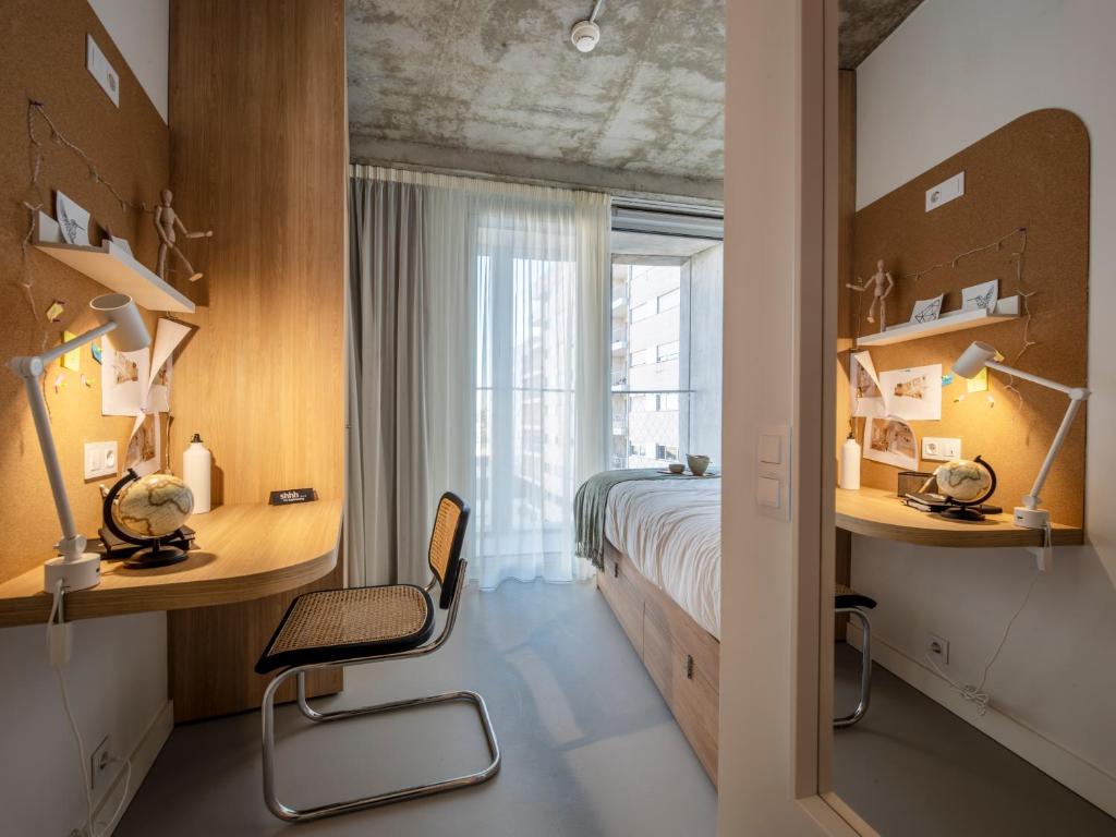 波尔图micampus Porto Tower的一间卧室配有一张床、一张桌子和一把椅子