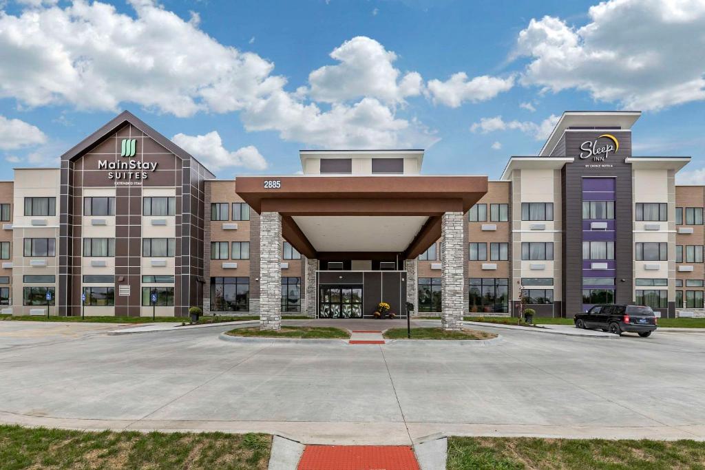 富兰克林Sleep Inn & Suites Milwaukee-Franklin的一座大型建筑,前面设有停车场