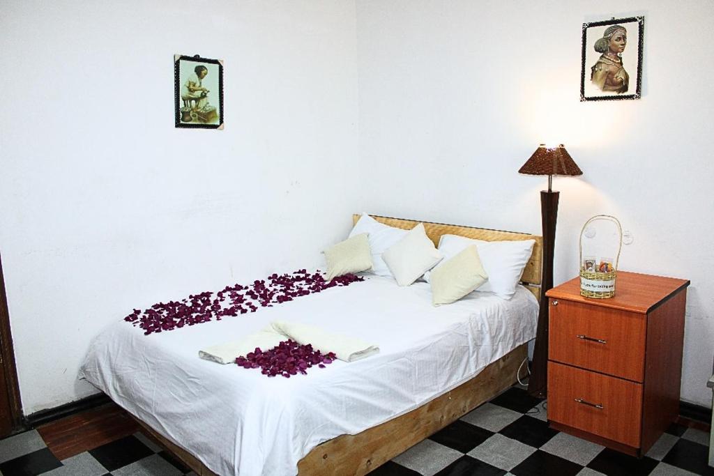 亚的斯亚贝巴Kind private room 8的一间卧室,床上有紫色鲜花