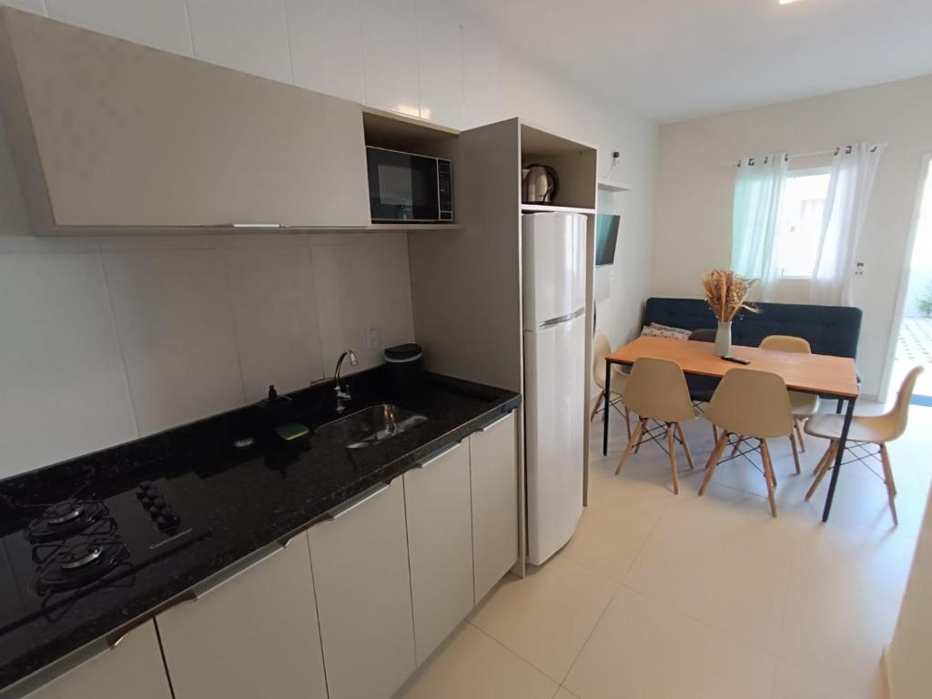 邦比尼亚斯Residencial Brisa do Mar 2的厨房以及带桌子和冰箱的用餐室