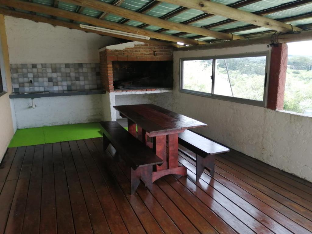 塞拉纳镇Cabaña Jacarandá的一间带长凳、桌子和窗户的房间
