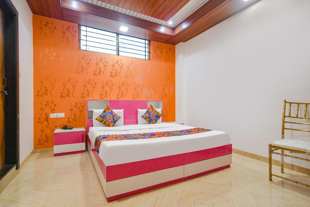 印多尔FabExpress Dream paradise的一间卧室配有一张橙色墙壁的床