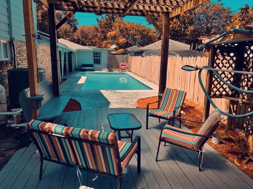 休斯顿Home for summer with pool, pool table, outdoor kitchen,patio and balcony的一个带椅子的甲板和一个游泳池