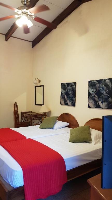 萨玛拉萨马拉海滩酒店的一间卧室配有两张床和吊扇
