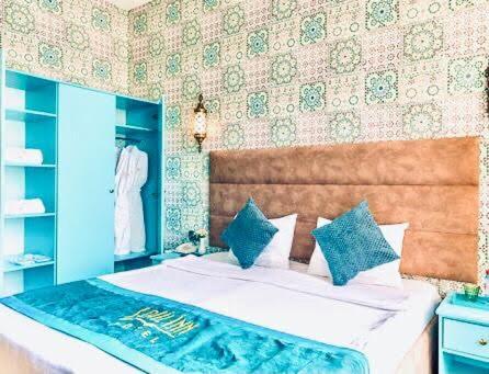 巴库Sahil Inn Baku Hotel Formula 1 View的一间卧室配有一张带蓝色枕头的大床