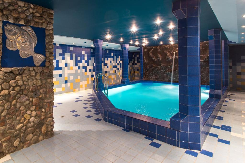 德鲁斯基宁凯加利亚酒店的一个带蓝色瓷砖地板的房间的小型游泳池