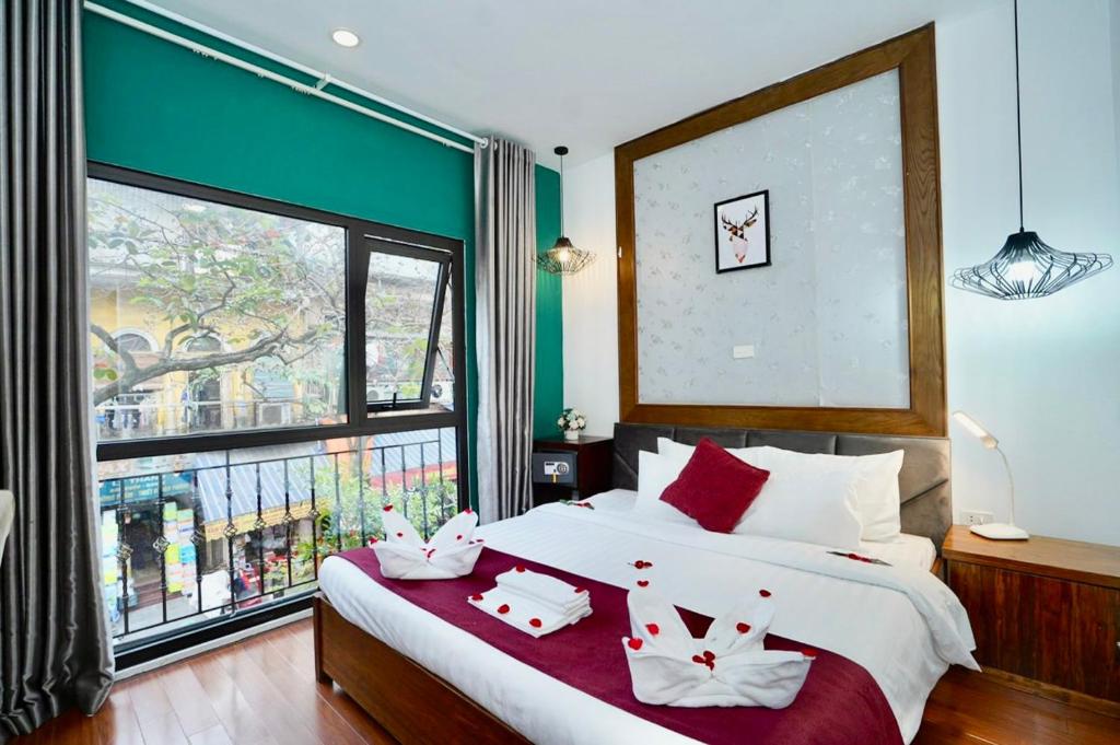 河内NT Elysian hotel的一间卧室设有一张大床和一个大窗户