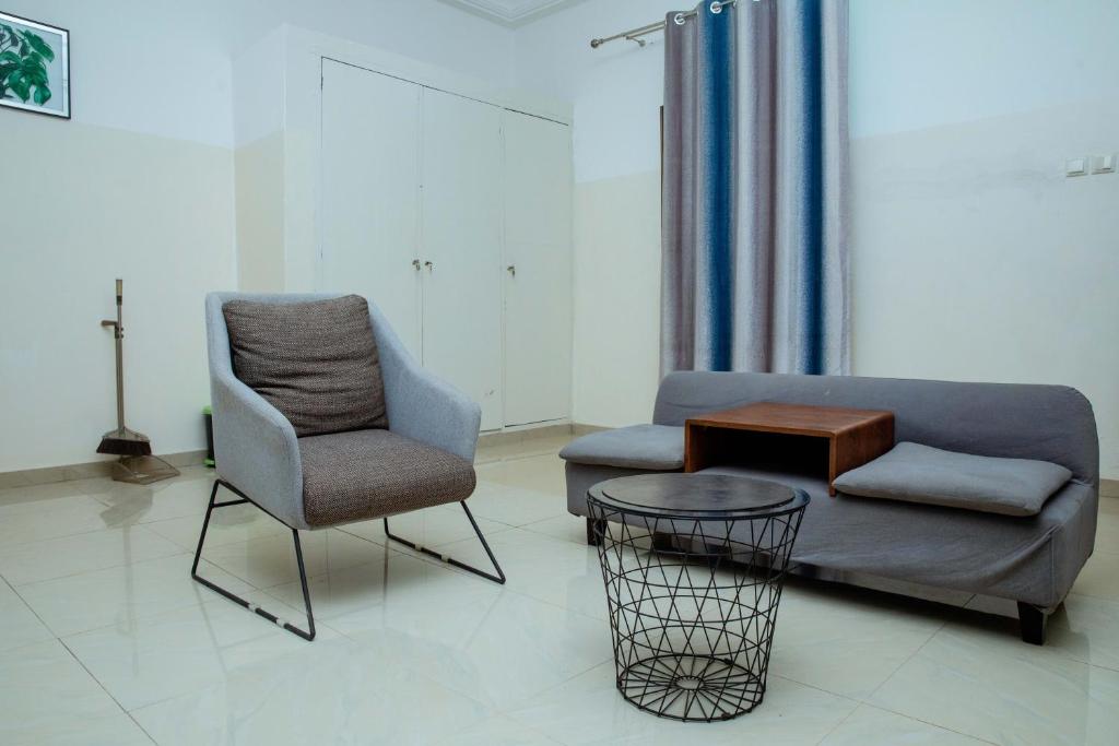 洛美Studio meublé R1的客厅配有沙发和椅子