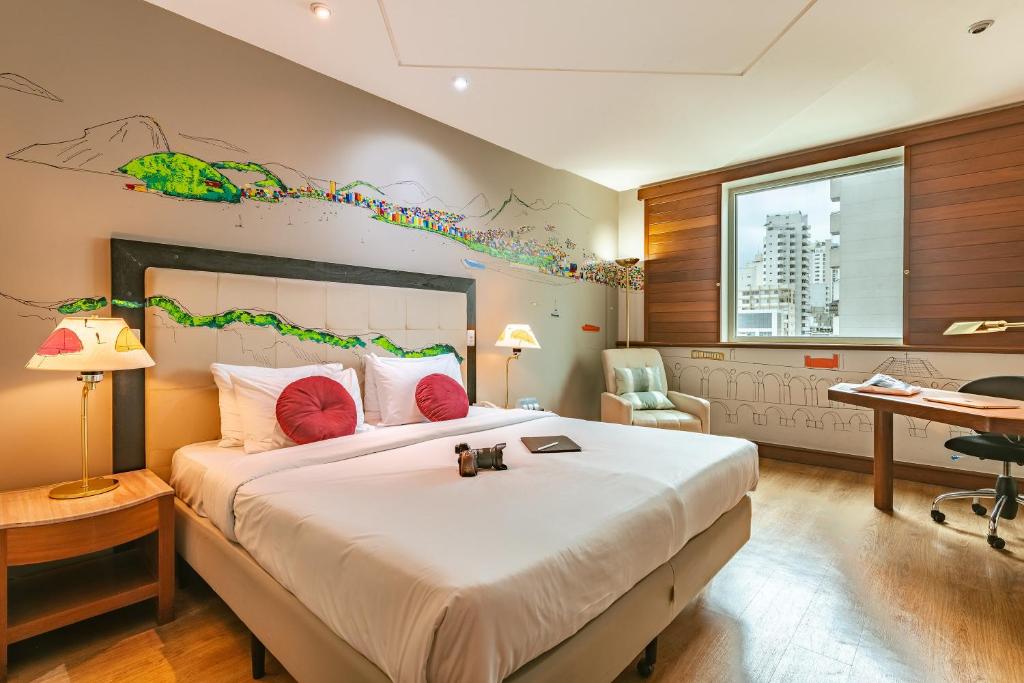 圣保罗圣保罗佩斯塔纳酒店的一间卧室配有一张大床和一张书桌