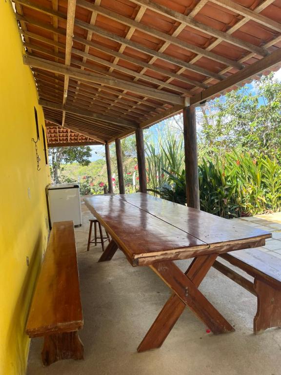 MartinsChácara Tantan - Martins RN的一张木餐桌,坐在屋顶下