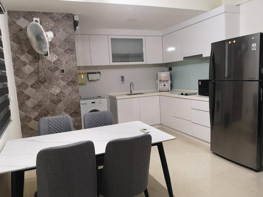 新山Summer Escapes的厨房配有桌椅和冰箱。
