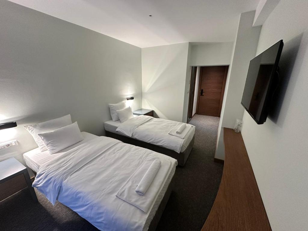普列夫利亚Hotel Pljevlja的酒店客房设有两张床和一台平面电视。