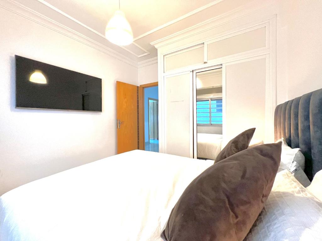丹吉尔Tanger SABOR Central Aparts Fibre -ONLY FAMILY的卧室配有一张床铺,墙上配有电视