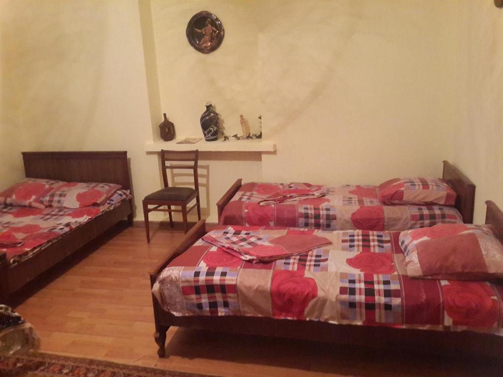 第比利斯柠檬家庭旅馆的一间卧室配有两张床和一张桌子及椅子