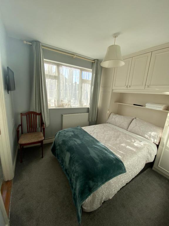 都柏林Baldara House的卧室配有床、椅子和窗户。