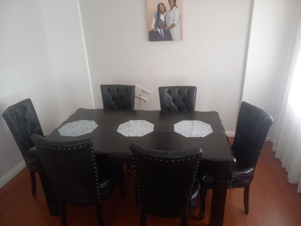 Kitengela Amreff Nyumbani villas的一张黑色餐桌,配有四把黑色椅子