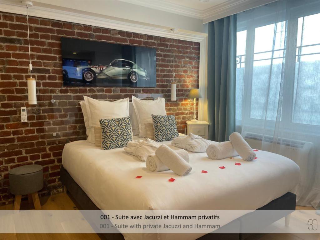 里尔奥30号旅馆的卧室配有一张白色大床和砖墙