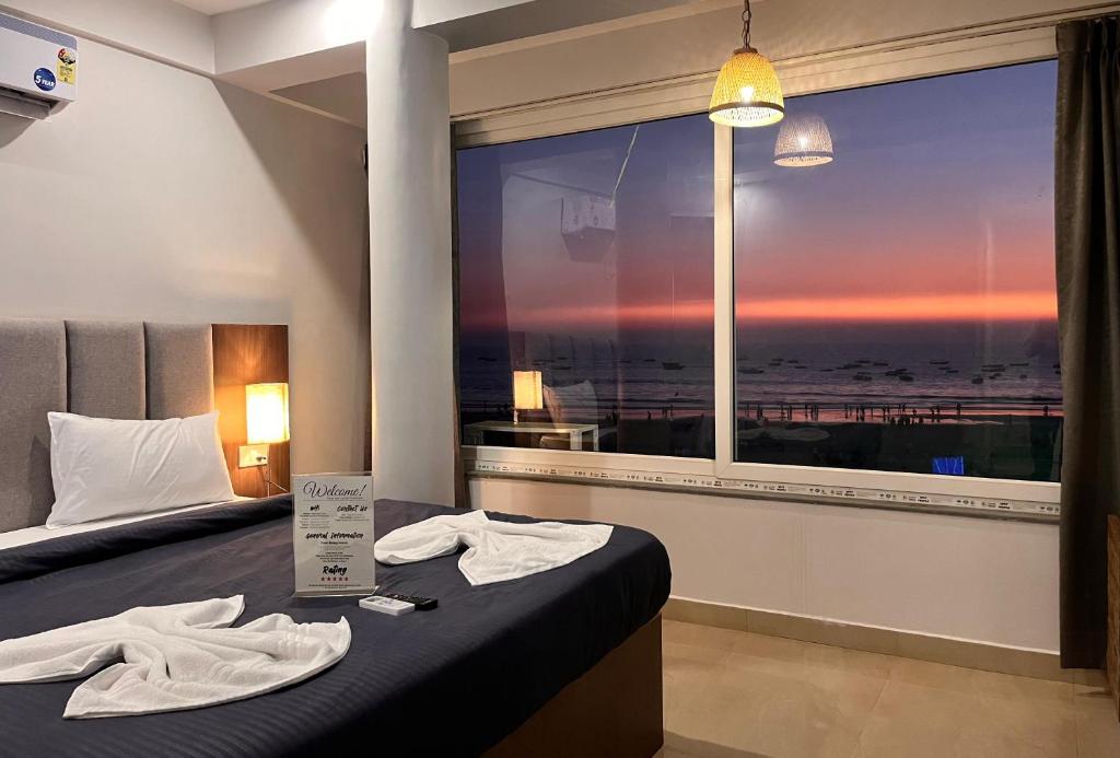 巴加Baga beach front的酒店客房设有一张床和一个大窗户