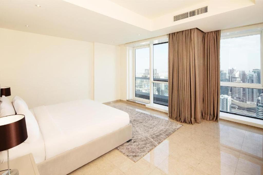 迪拜Marina Two Bedroom With Balcony - KV Hotels的白色卧室设有床和大窗户