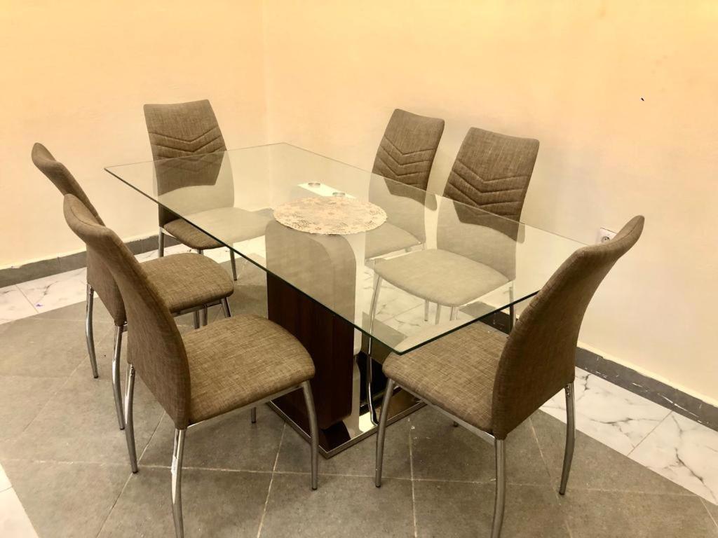 EmanaRESIDENCE E.P的玻璃餐桌、椅子和玻璃桌