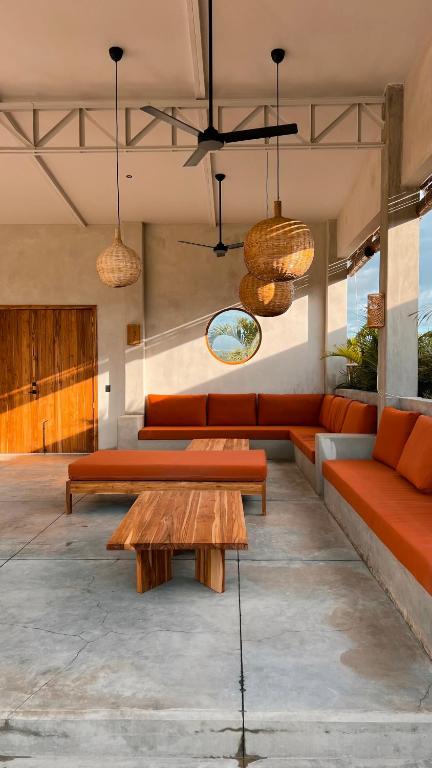 波波约Tukasa - Surfhouse Popoyo的客厅配有橙色沙发和桌子