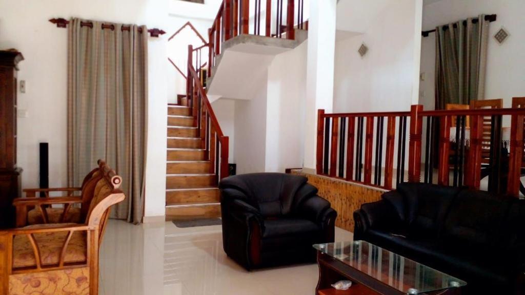 Gonapinuwala WestVero villa的带沙发、椅子和楼梯的客厅